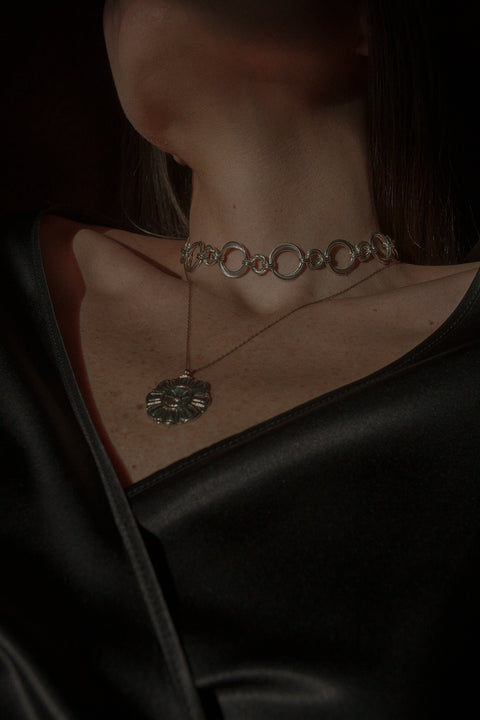 Podkreśl swój wyjątkowy styl dzięki naszemu chokerowi typu łańcuch z kolekcji WIĘZI UMIAR biżuteria. Wykonany ręcznie z setek delikatnych ogniw, ten choker emanuje elegancją i subtelnością. Z długością 42 cm doskonale dopasowuje się do szyi, dodając niepowtarzalnego uroku każdej stylizacji. Dostępny w dwóch wariantach: srebrze 925 oraz srebrze 925 pozłacanym 24-karatowym złotem, ten model to połączenie tradycyjnych rzemieślniczych technik z nowoczesnym wzornictwem.